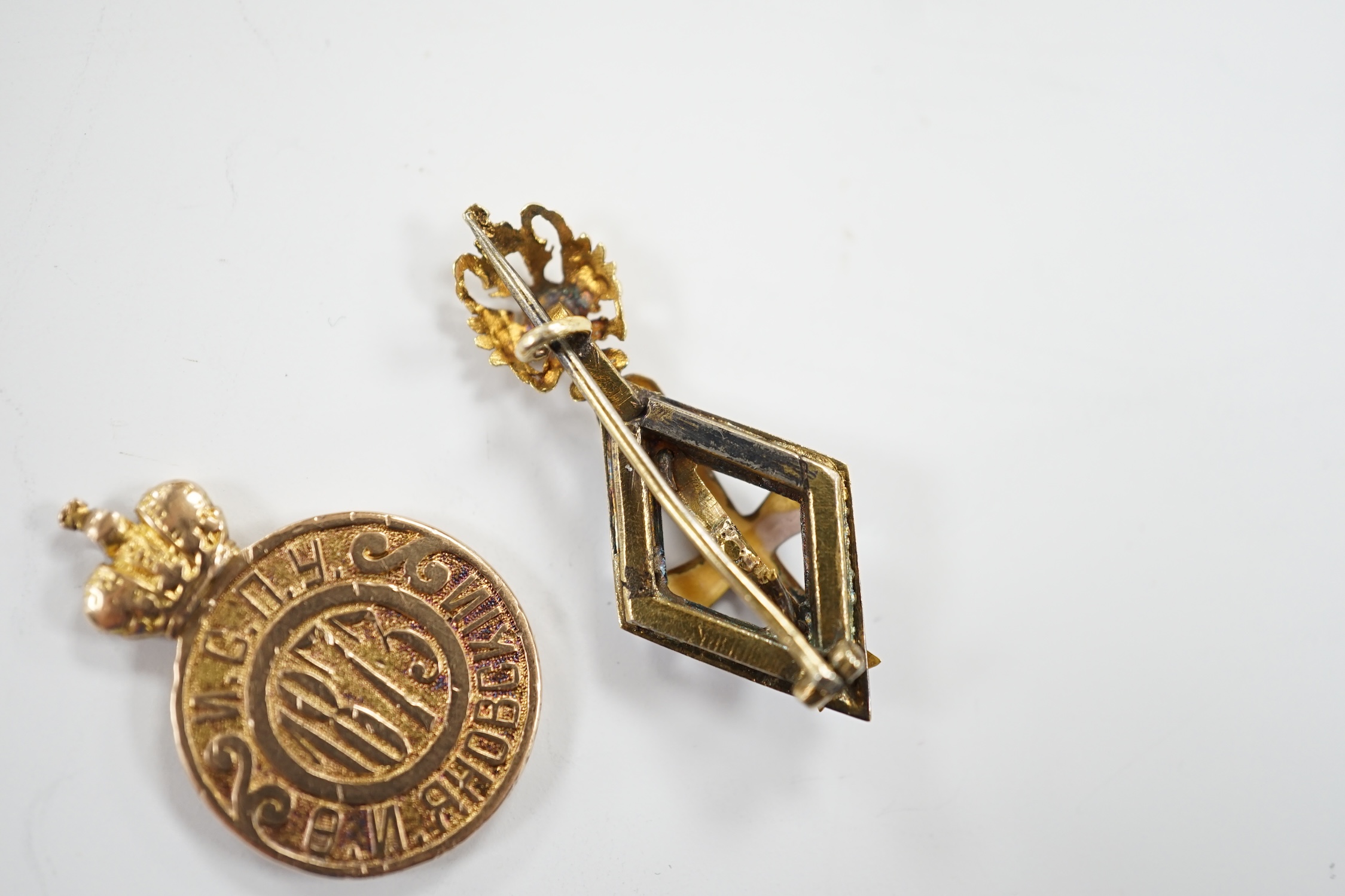 A Russian gilt white metal and enamel graduation from University of St Petersburg badge, 33mm and a yellow metal (tests as 14k) token for University Graduates, 5.1 grams.